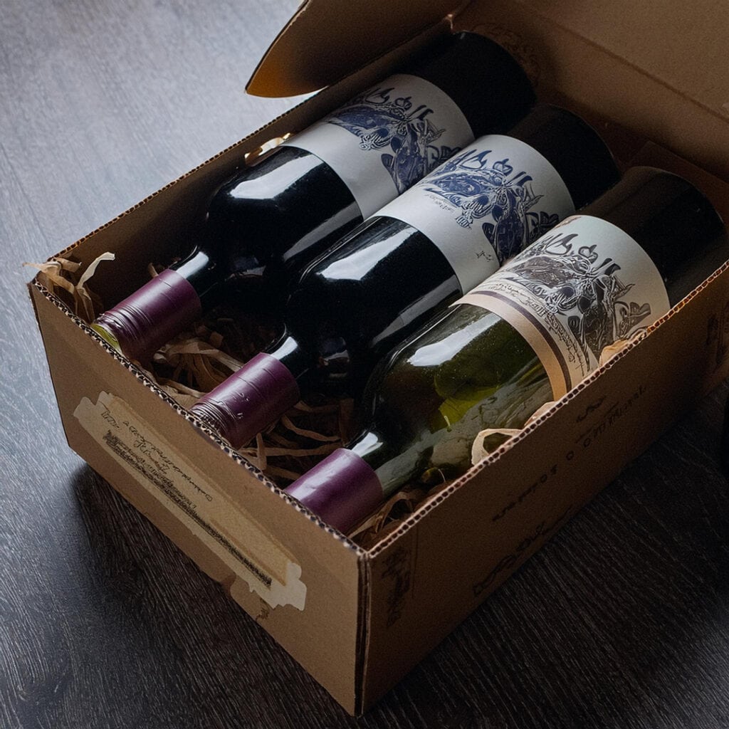 alcohol subscription boxes with 3 bottles of wine lying on a table